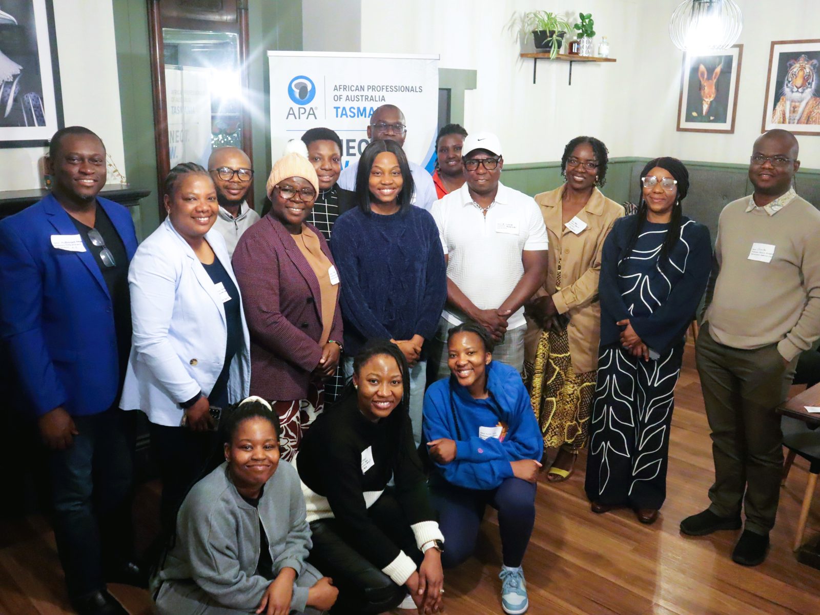 APA Tasmania members gathered in front of the chapter banner at a community event